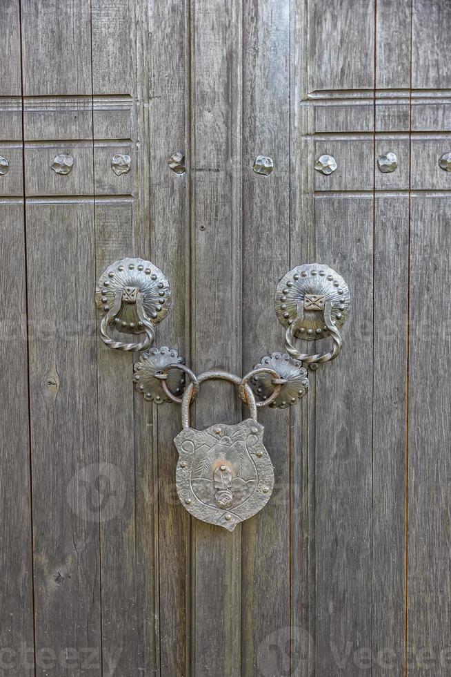 a velho de madeira porta trancado com uma grande vintage cadeado. verdade Vila estilo foto