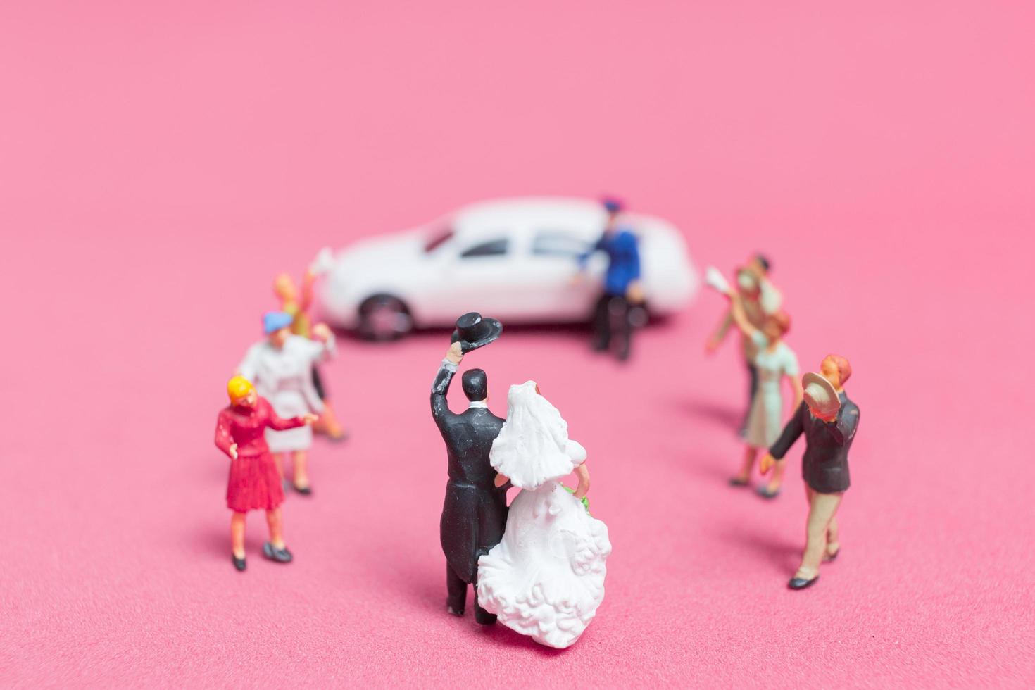 casamento em miniatura, uma noiva e um noivo em um fundo rosa foto