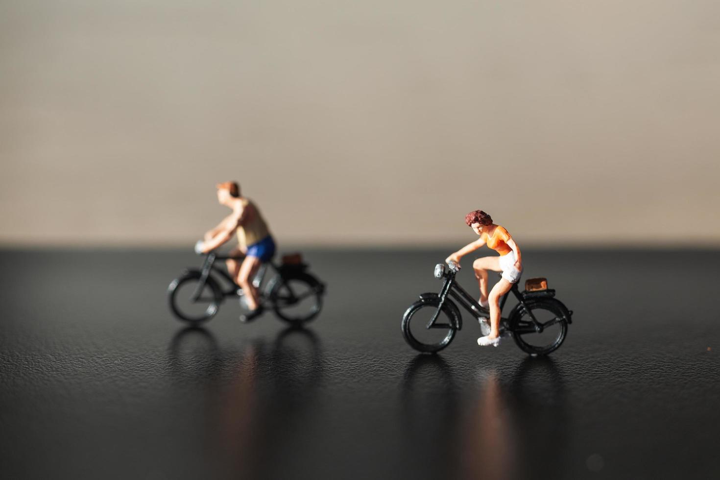 viajantes em miniatura andando de bicicleta, conceito de estilo de vida saudável foto