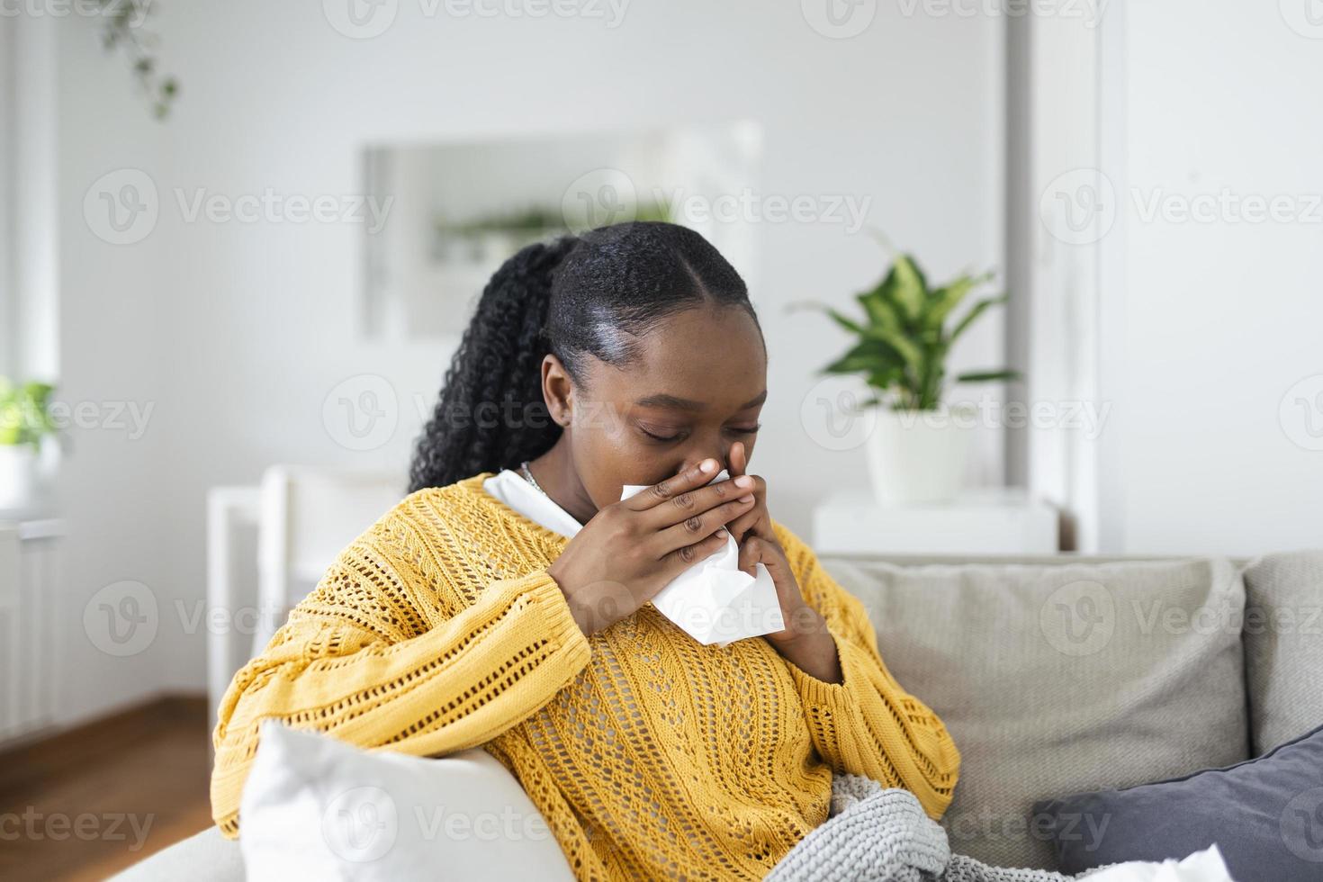 eu vou africano jovem mulher coberto com cobertor sopro corrida nariz obteve febre apanhado frio espirros dentro lenço de papel sentar em sofá, doente alérgico Preto menina tendo alergia sintomas tosse às lar, gripe conceito foto