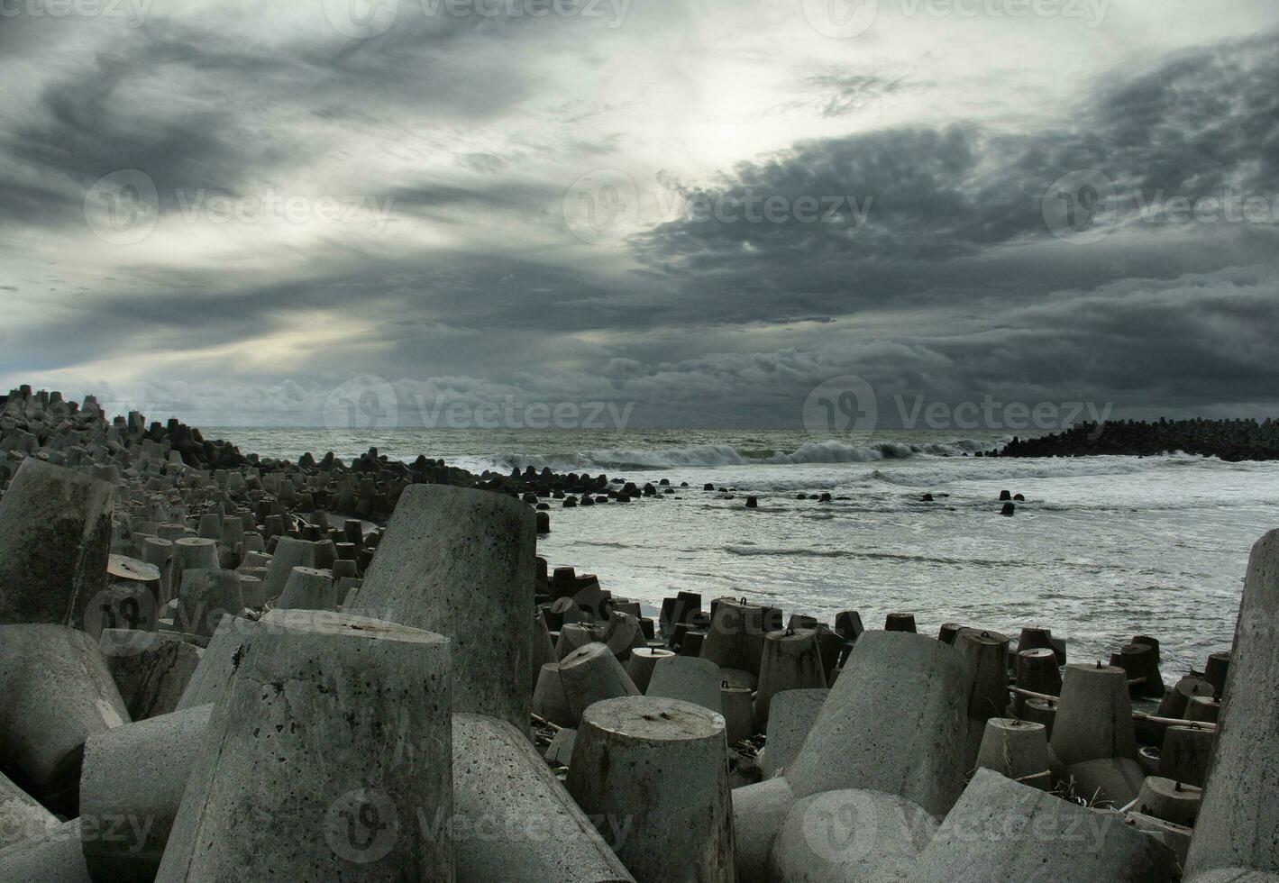 vista para o mar com pedras enormes e uma onda foto