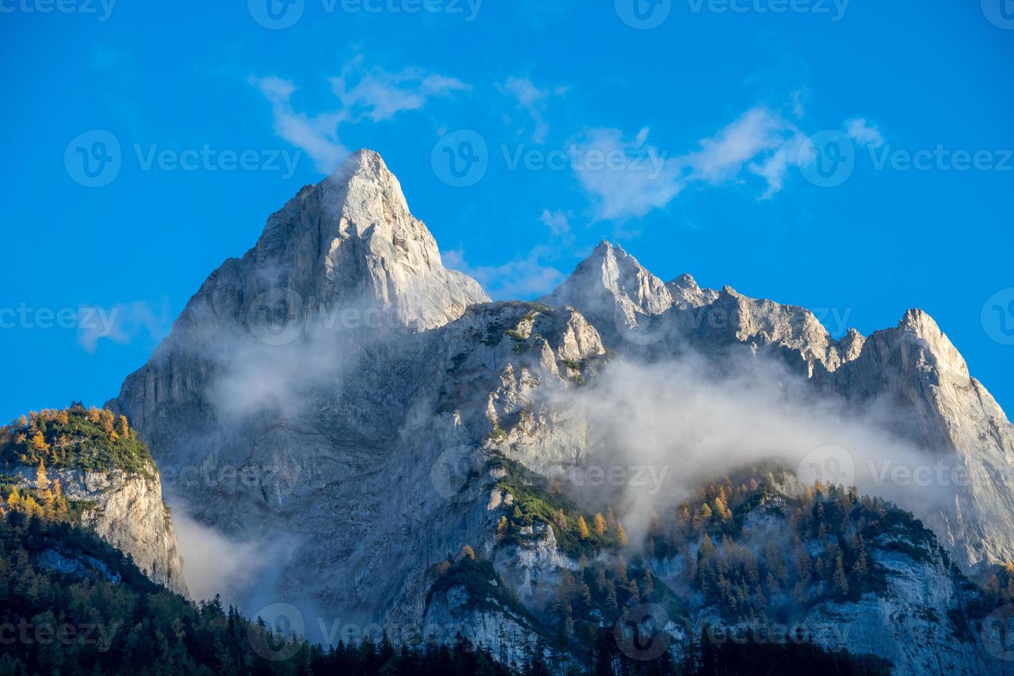 impressionante montanha formação debaixo azul céu cercado de nuvens foto