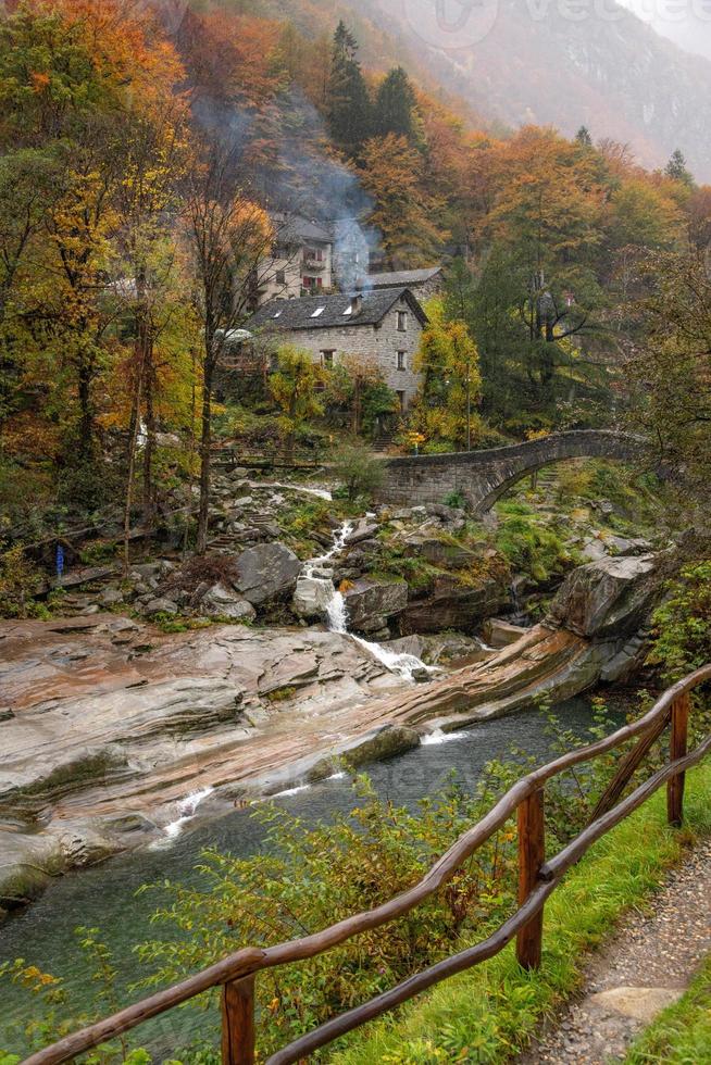 uma pequeno Vila com uma pedra ponte dentro outono chuvoso clima foto