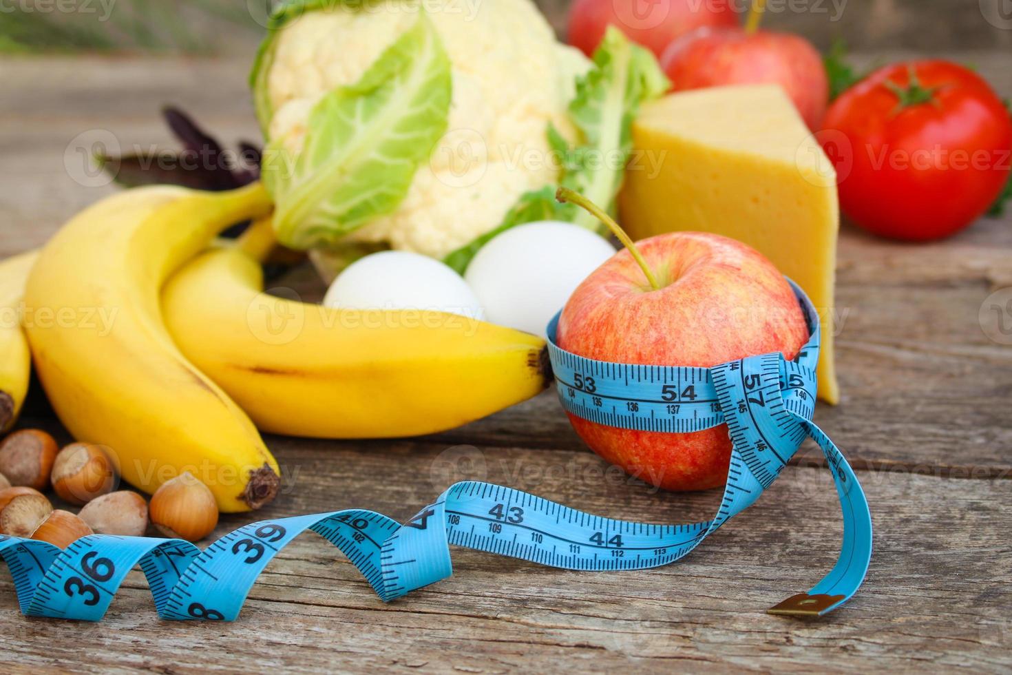 frutas e vegetais, fita a medida em velho de madeira fundo. conceito do apropriado nutrição. foto