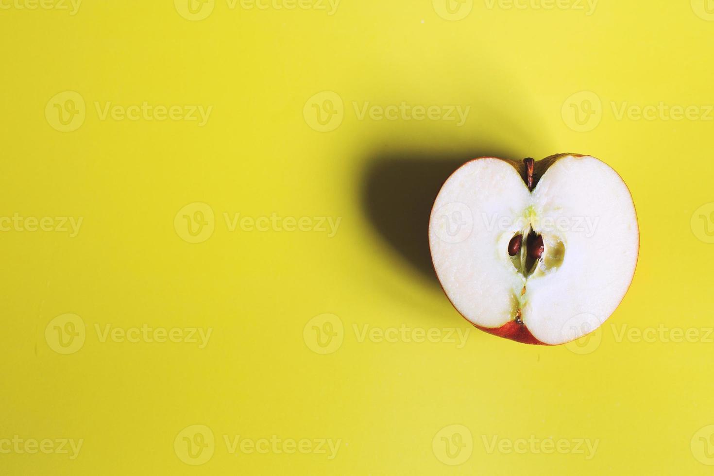 maçã cortar em uma amarelo fundo. metade maçã foto