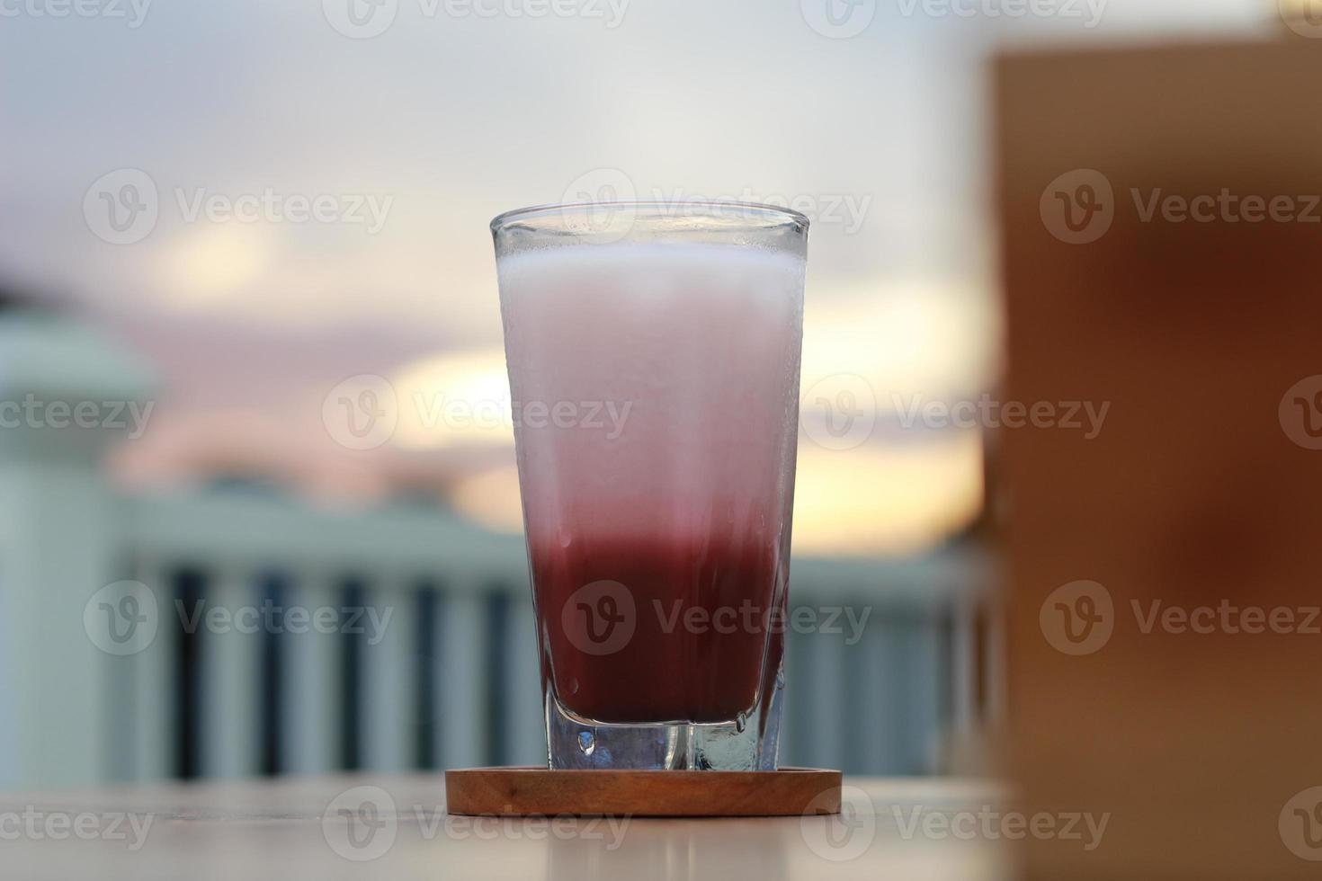 uma vidro do vermelho veludo café com leite servido frio em a mesa. foto