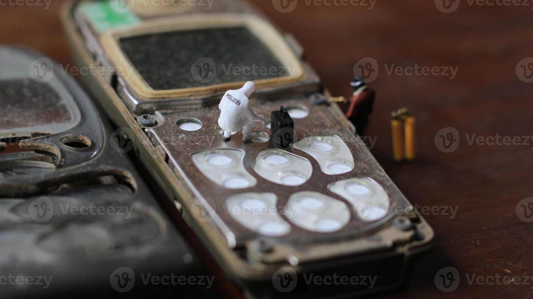 miniatura figura do uma técnico reparação a velho quebrado célula telefone. trabalhando técnico conceito. foto