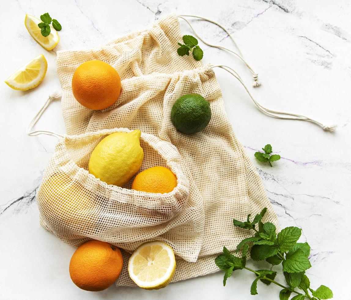 suculentas frutas cítricas maduras em sacolas ecológicas foto