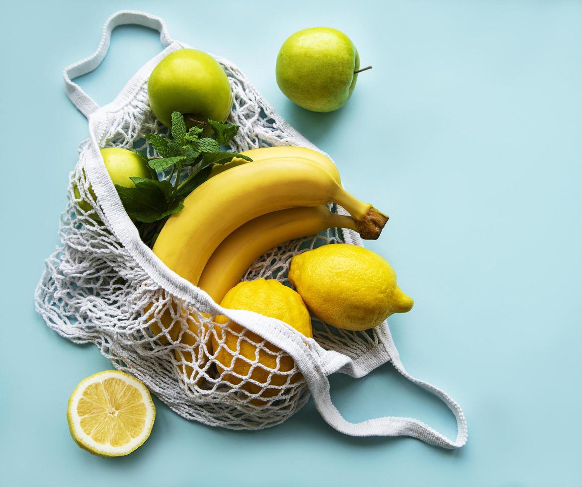 suculentas frutas cítricas maduras e bananas em uma sacola de compras ecológica foto