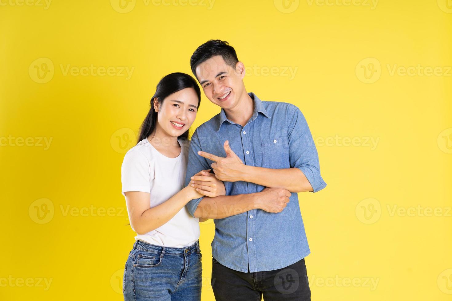 imagem de casal asiático posando em fundo amarelo foto