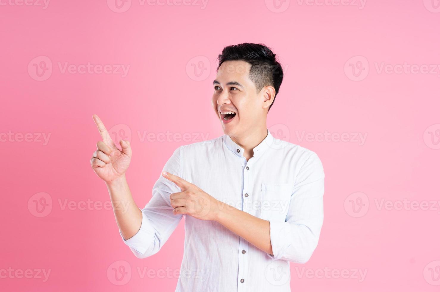 retrato de homem asiático posando em fundo rosa foto