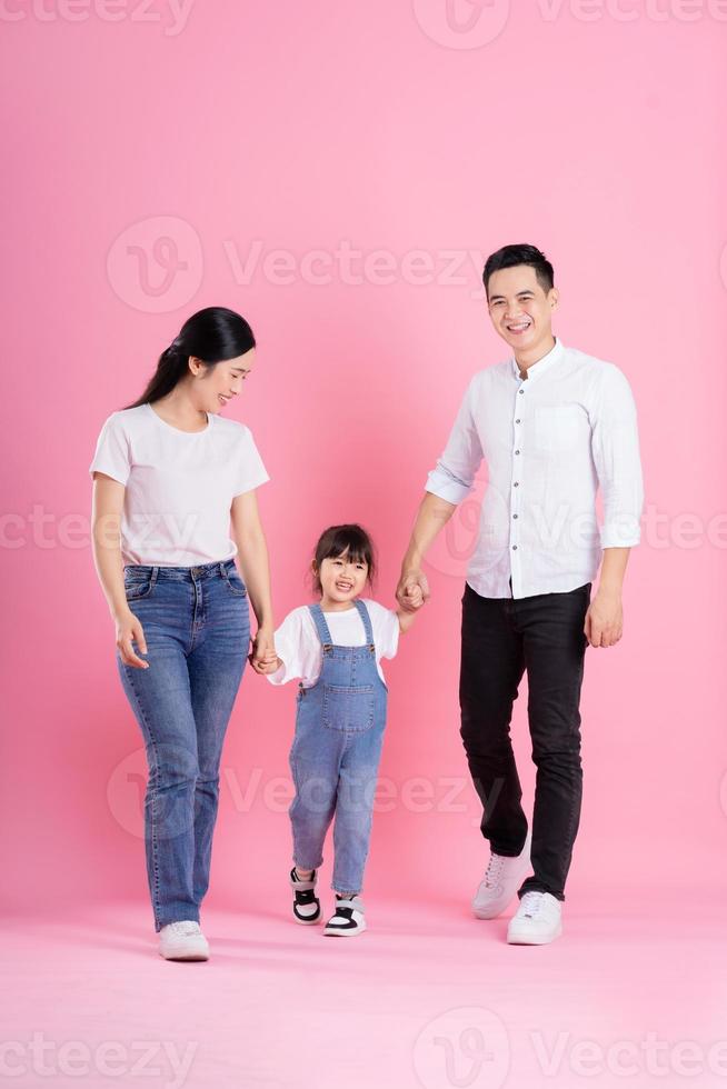 imagem de família asiática jovem feliz, isolada no fundo rosa foto