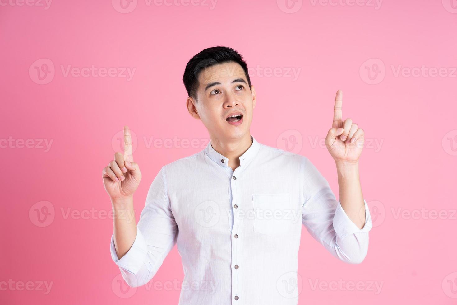 retrato de homem asiático posando em fundo rosa foto