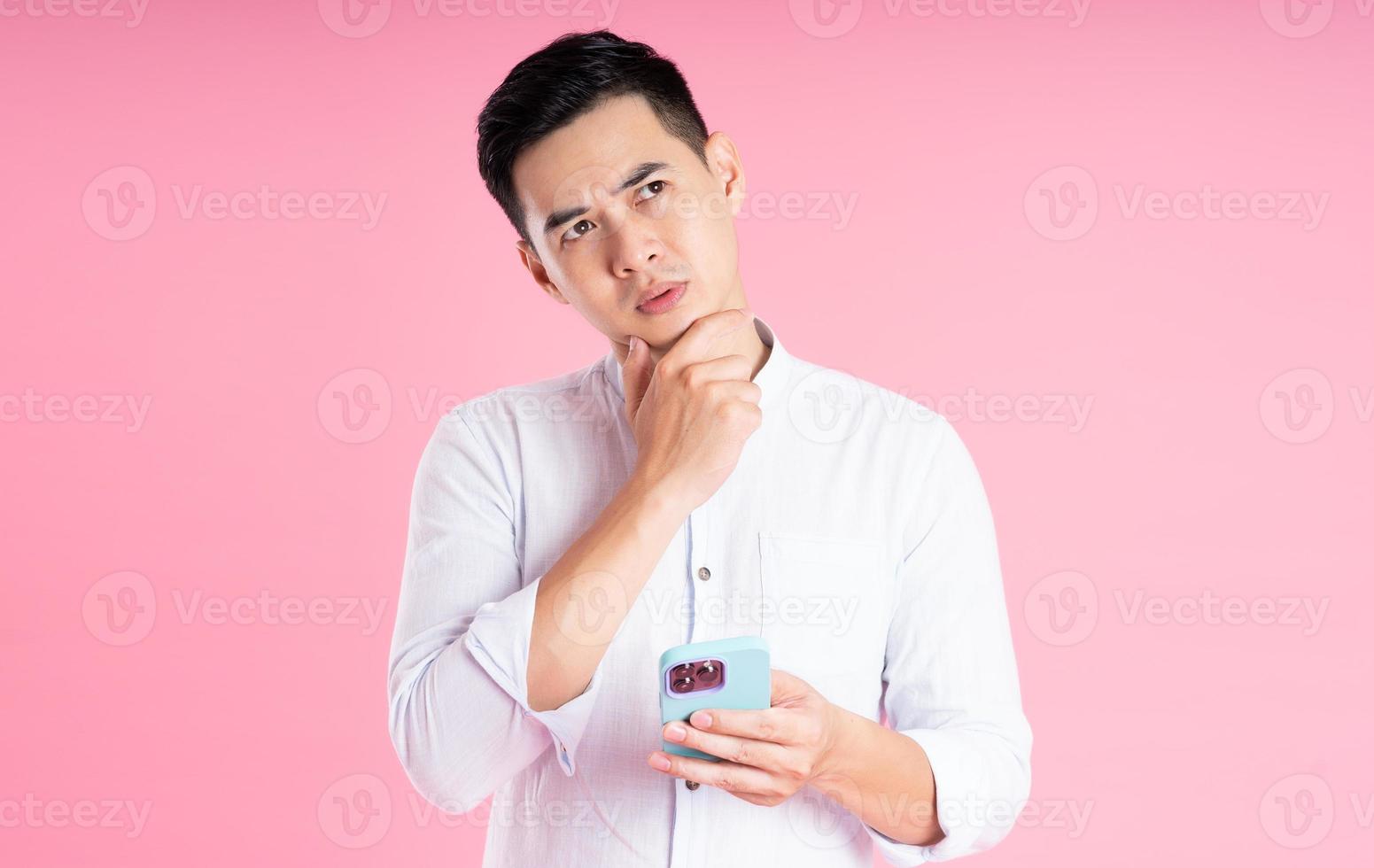 retrato de homem asiático posando em fundo rosa foto