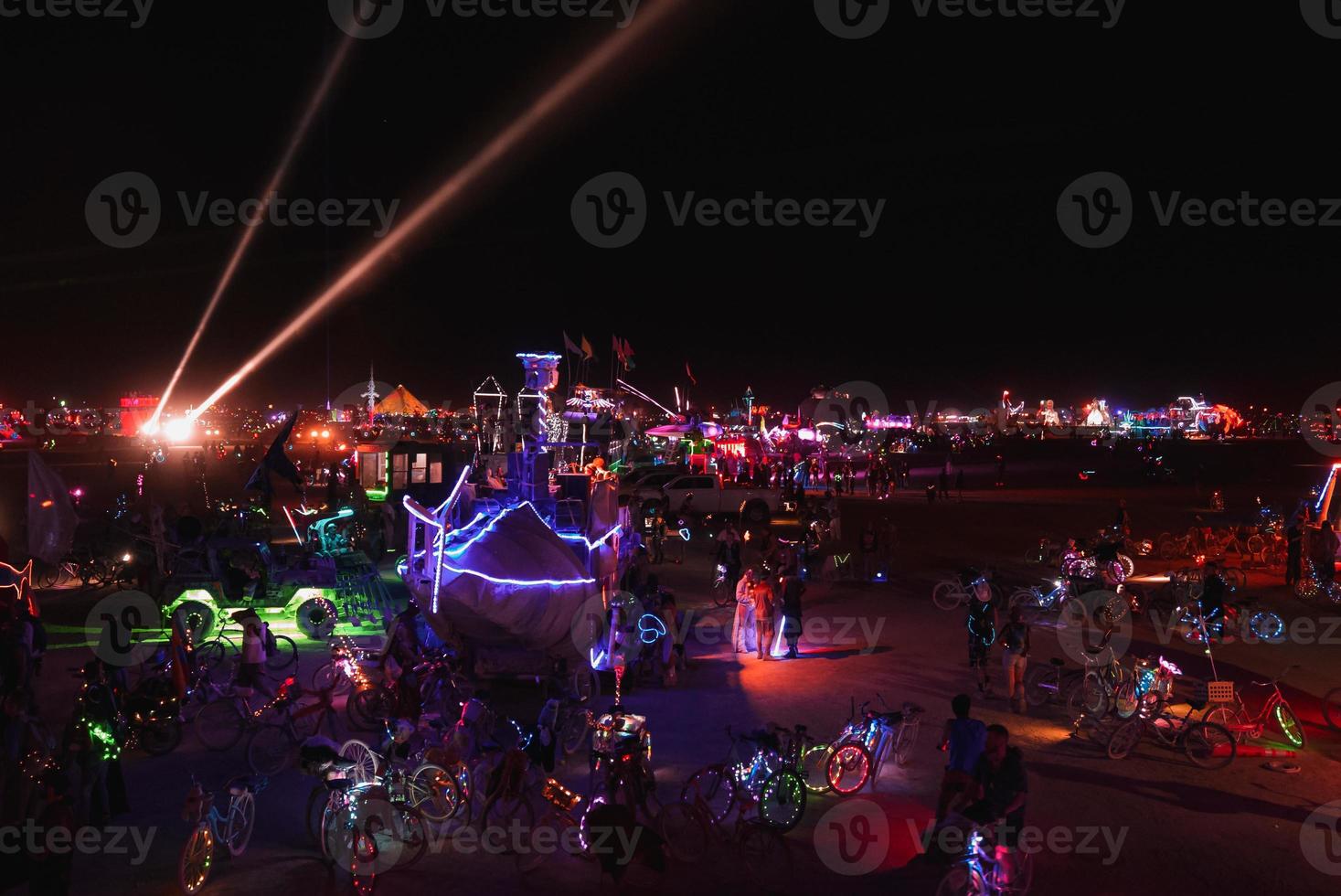 pessoas caminhando para pôr do sol às uma festival dentro a deserto às a queimando homem festival. foto