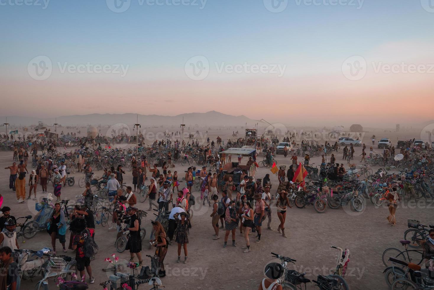 pessoas caminhando para pôr do sol às uma festival dentro a deserto às a queimando homem festival. foto