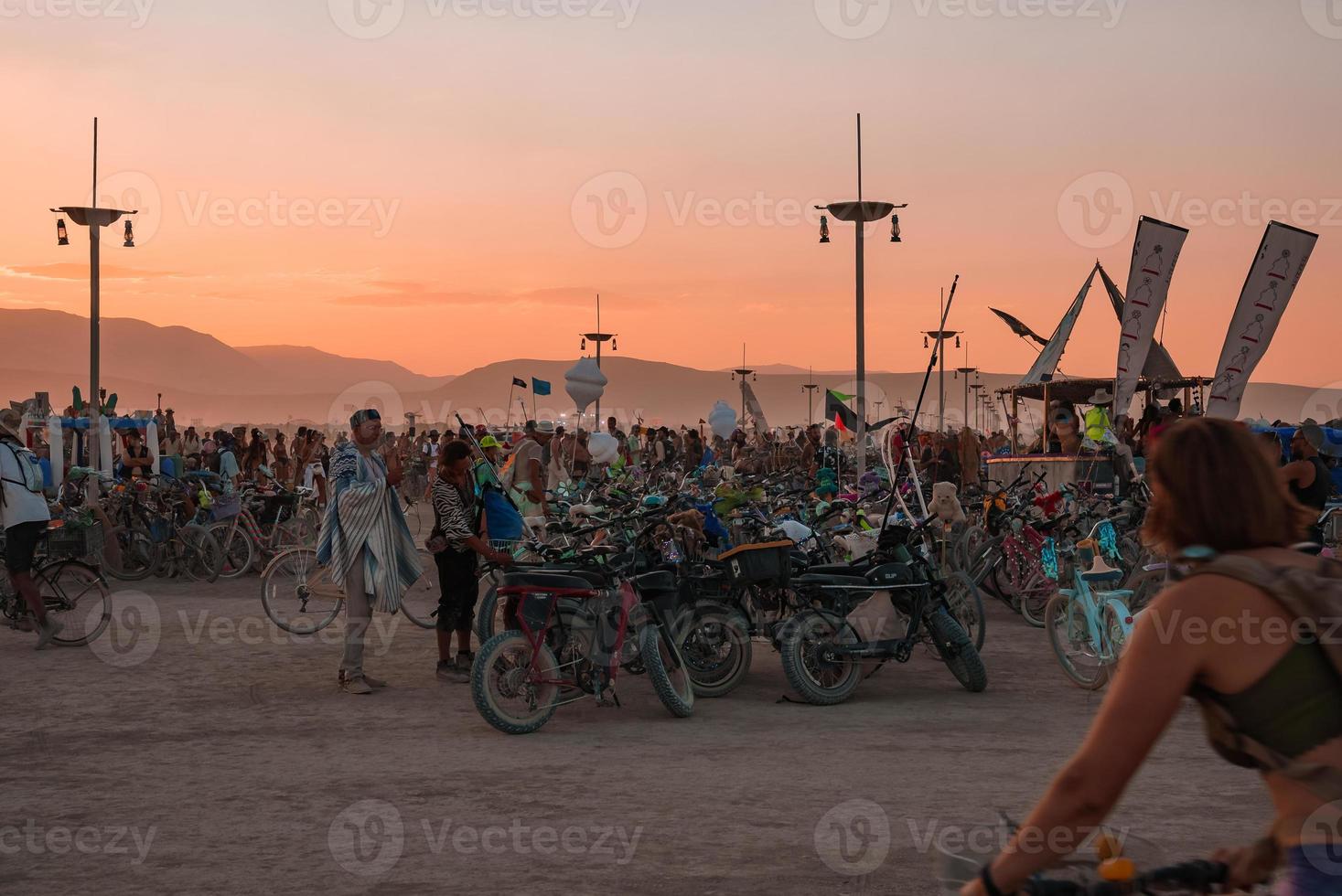 pessoas caminhando para pôr do sol às uma festival dentro a deserto às a queimando homem festival. foto