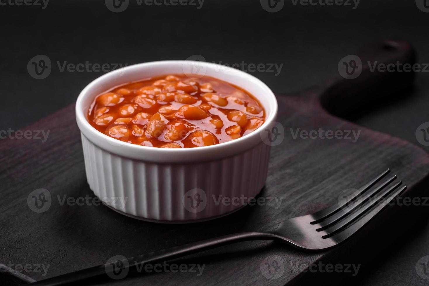 delicioso enlatado feijões dentro uma tomate dentro uma branco cerâmico tigela foto