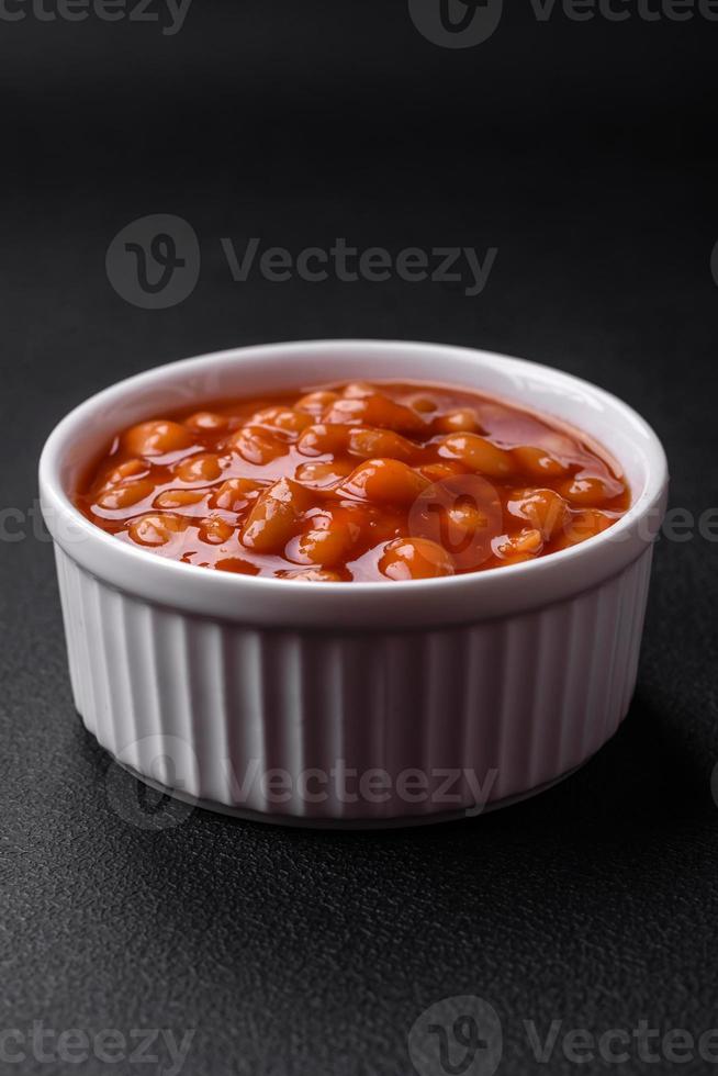 delicioso enlatado feijões dentro uma tomate dentro uma branco cerâmico tigela foto