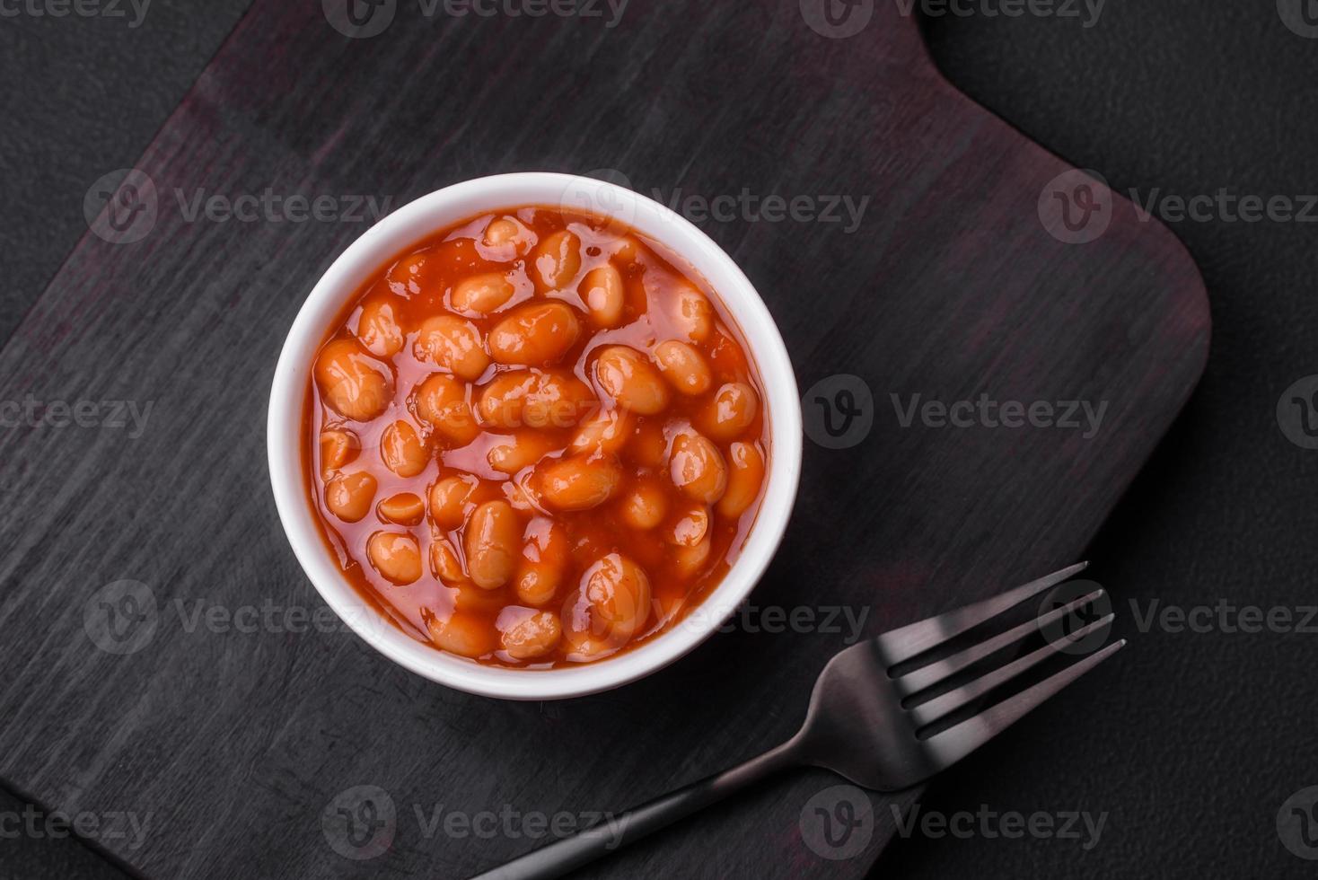 delicioso enlatado feijões dentro uma tomate dentro uma branco cerâmico tigela foto