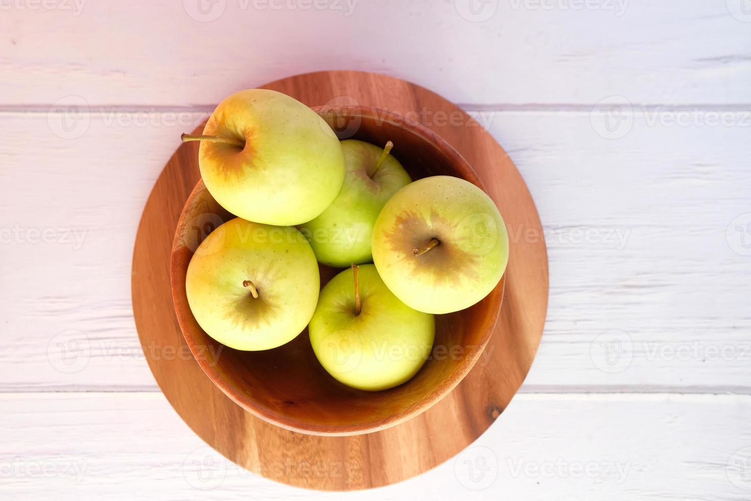 vista superior de maçãs verdes frescas em uma tigela de madeira foto