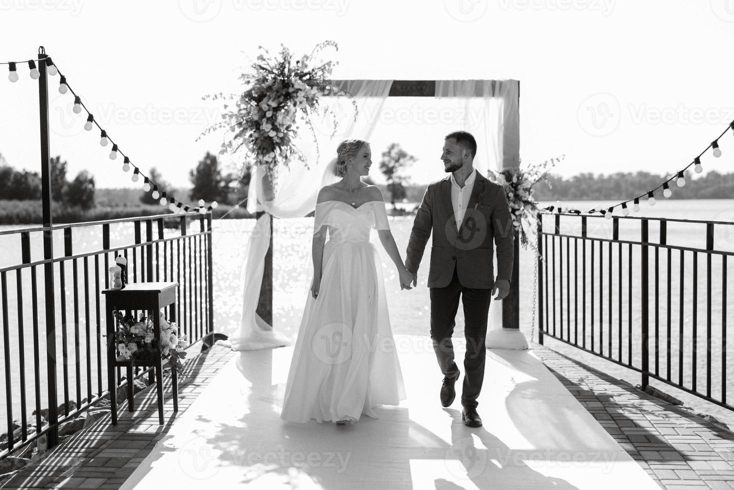 cerimônia de casamento em um píer alto perto do rio foto