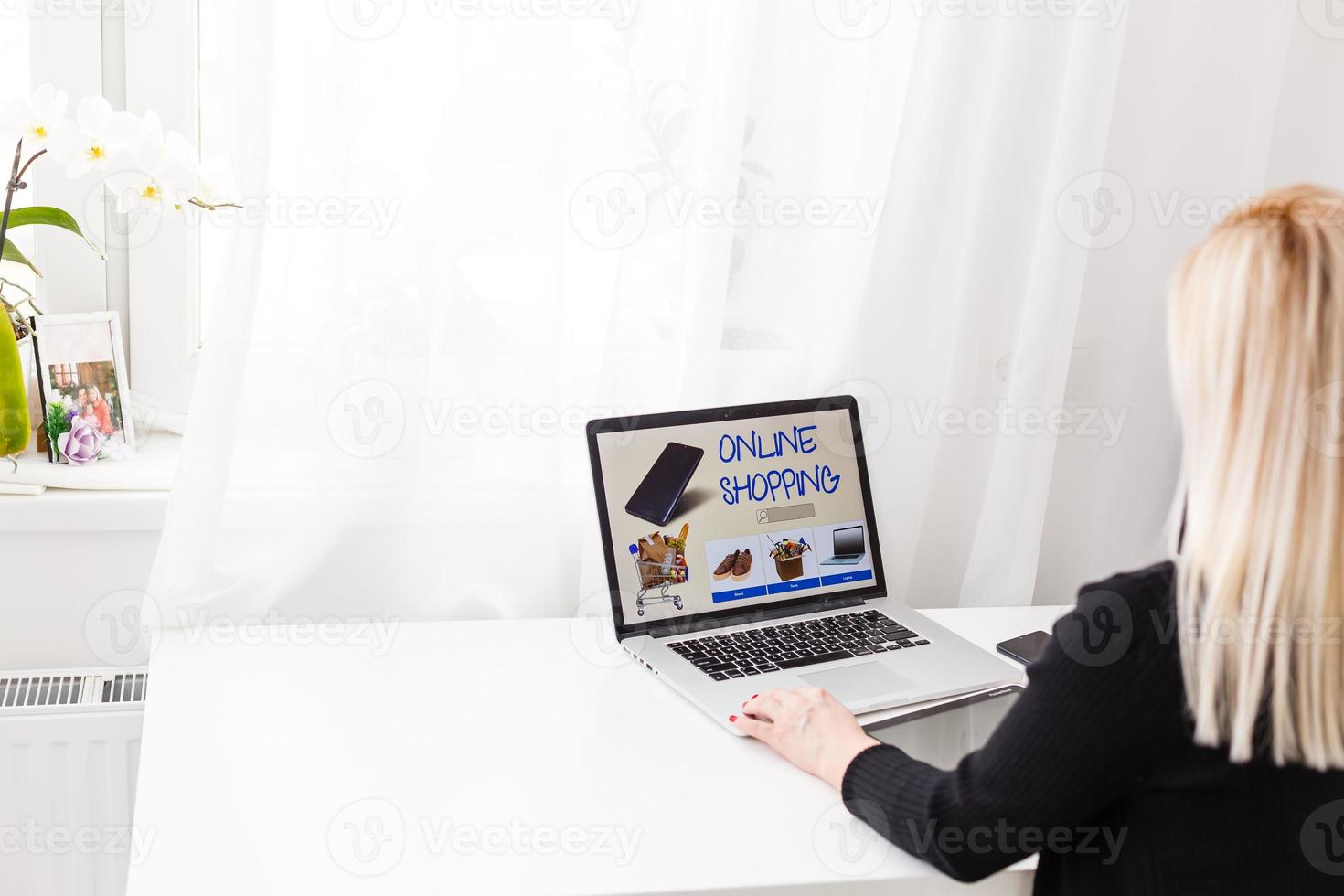 mulher compras conectados usando dela computador portátil às casa foto