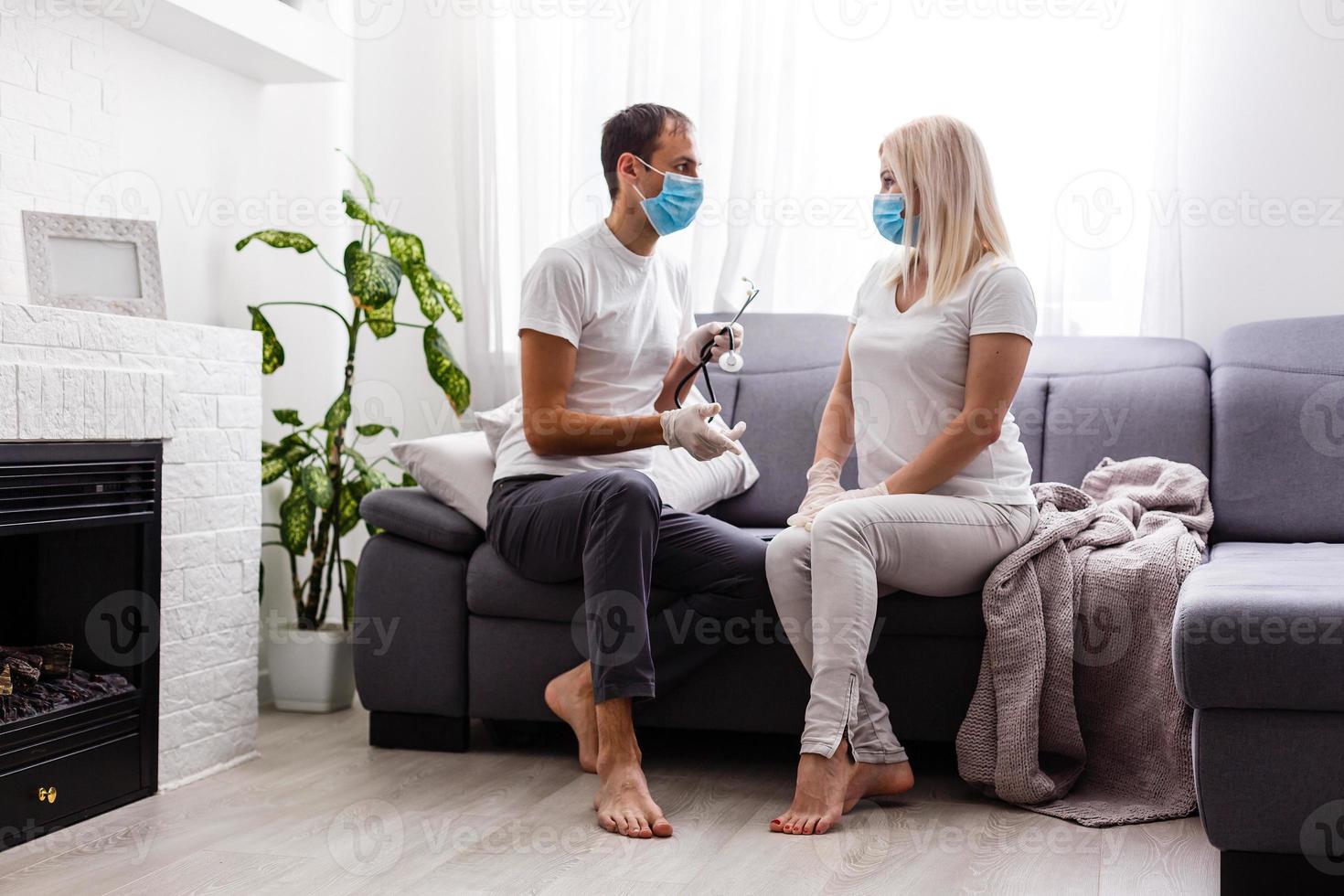 uma jovem casal é sentado às casa em quarentena voluntária. marido e esposa em quarentena coronavírus dentro protetora máscaras. Novo realidade. normal vida dentro isolamento. ler uma livro junto. Itália Europa covid-19 foto