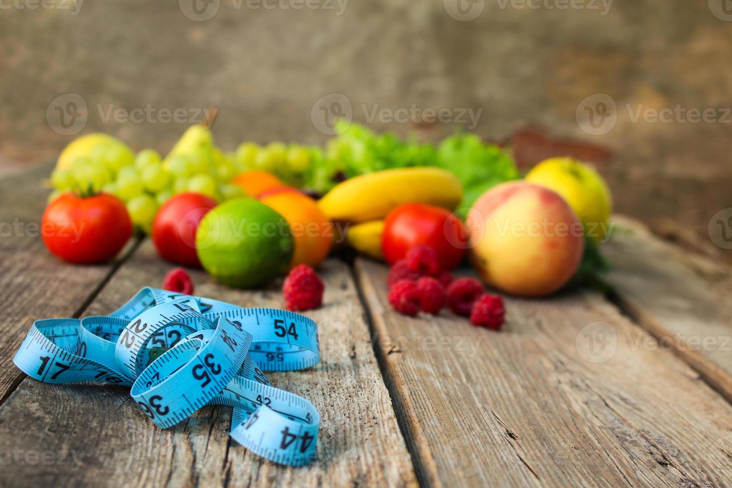 frutas, vegetais, a medida fita em de madeira fundo. foto