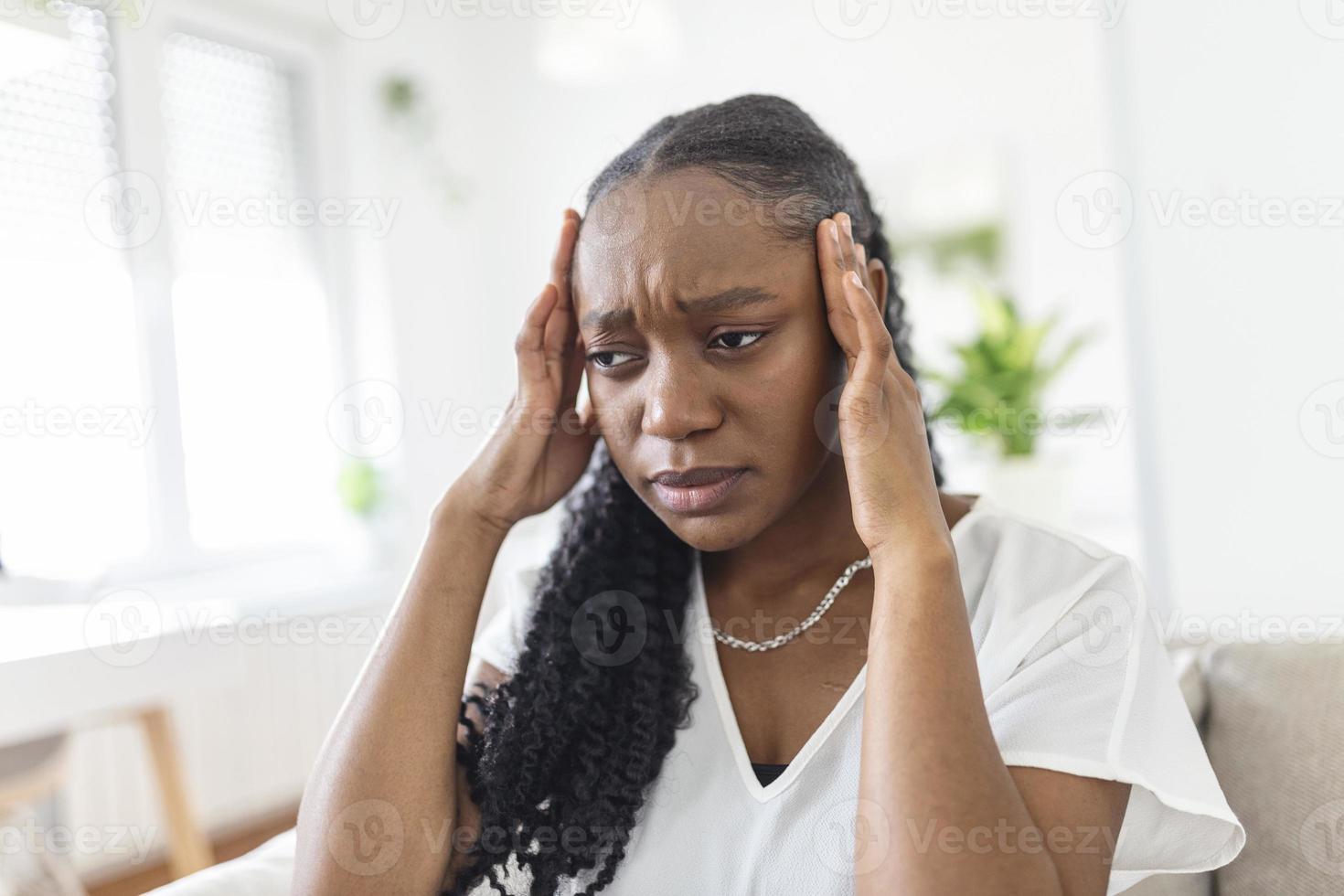 saúde e dor. estressada exausta jovem negra tendo forte dor de cabeça de tensão. retrato do close up da menina doente bonita que sofre da enxaqueca principal, sentindo a pressão e o stress. foto