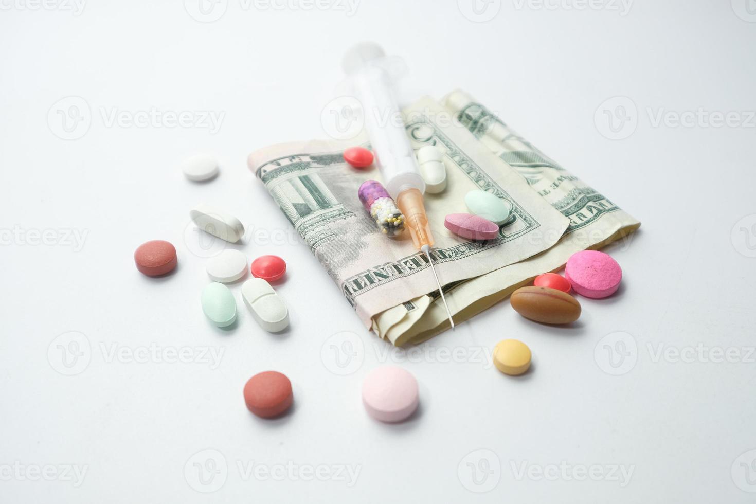 conceito de custo de saúde com dólares americanos, seringas e pílulas foto