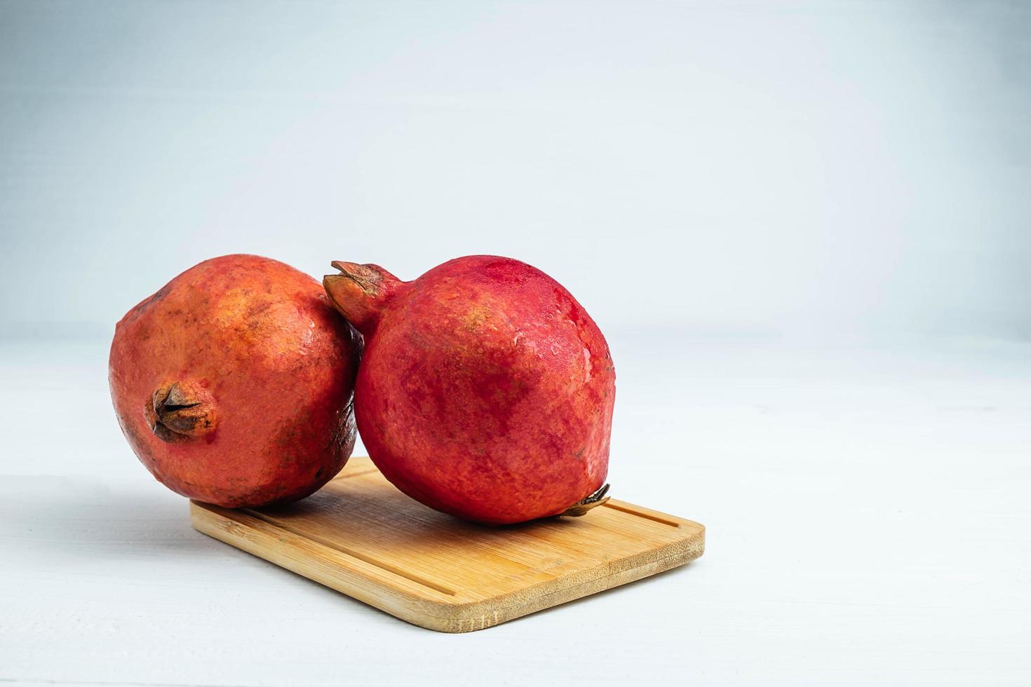 fruta de romã em uma placa de madeira foto