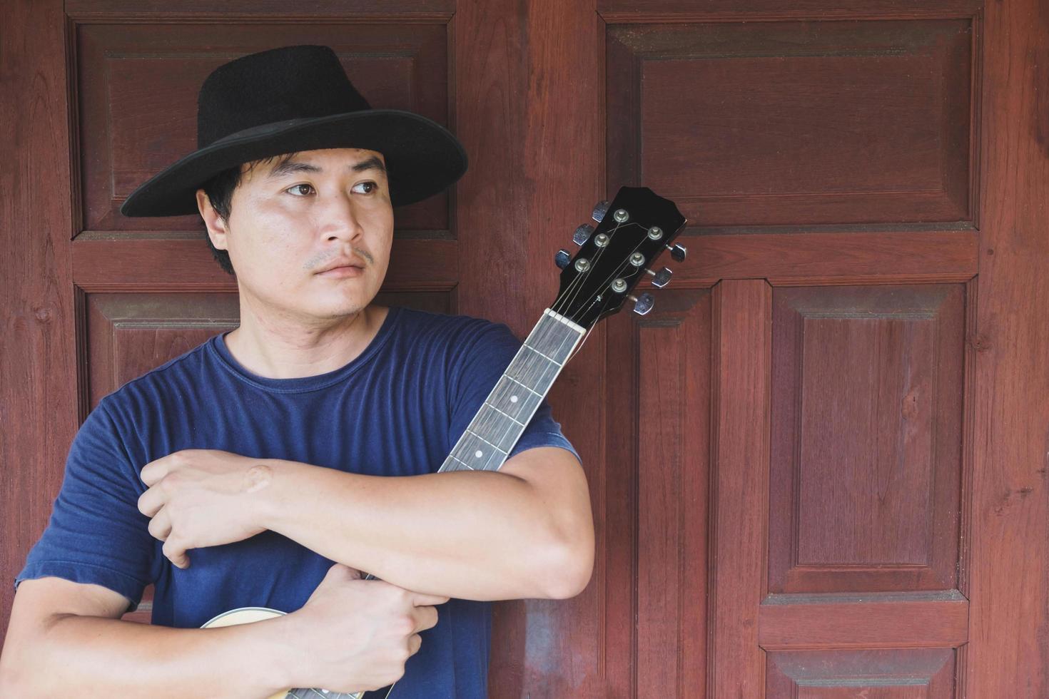 homem posando com uma guitarra foto