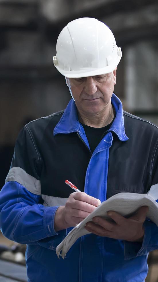 abril 19, 2022. bielorrússia, a cidade do gomil. metalúrgico plantar. retrato do uma trabalhador dentro uma protetora capacete com uma caderno. fábrica mestre. foto