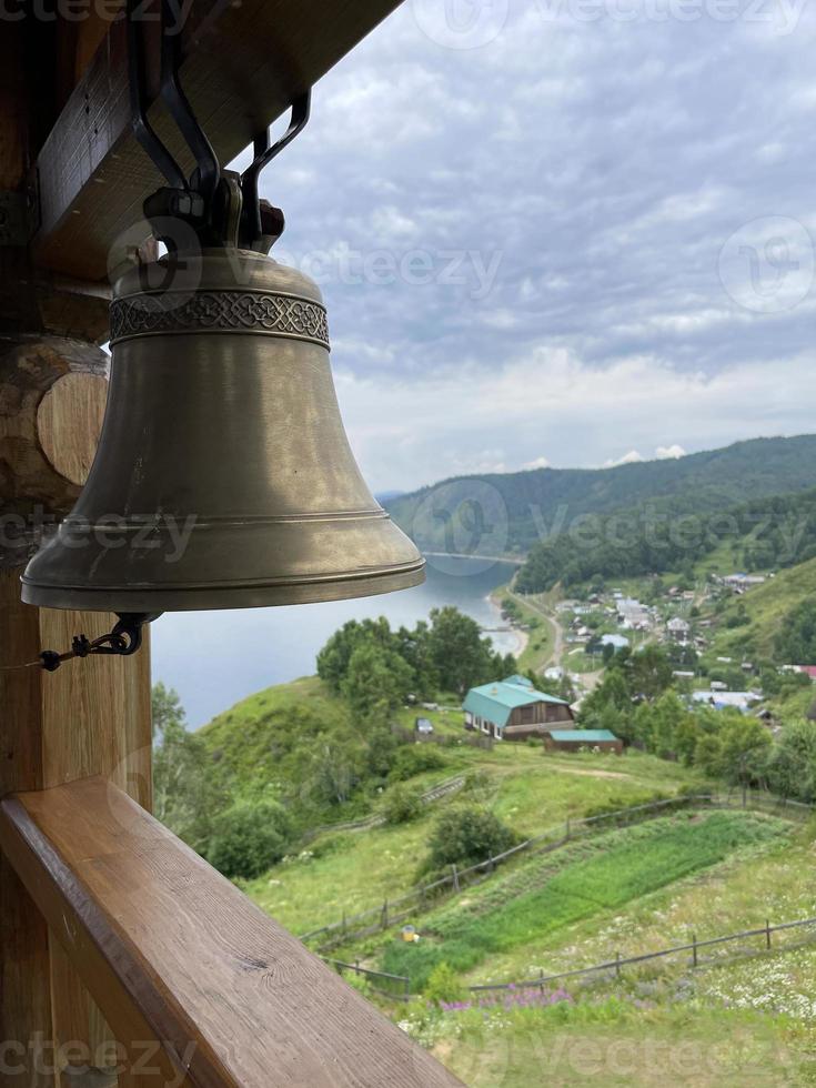 Sino dentro a campanário do uma cristão Igreja contra a pano de fundo do lago Baikal, Rússia foto