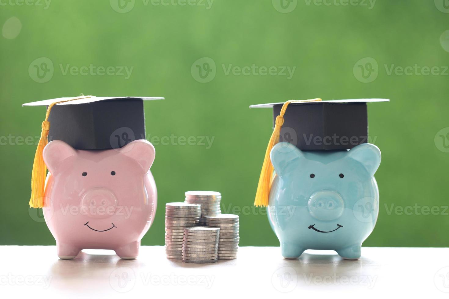 chapéus de formatura em cofrinhos e uma pilha de moedas em um fundo verde natural, economizando dinheiro para o conceito de educação foto