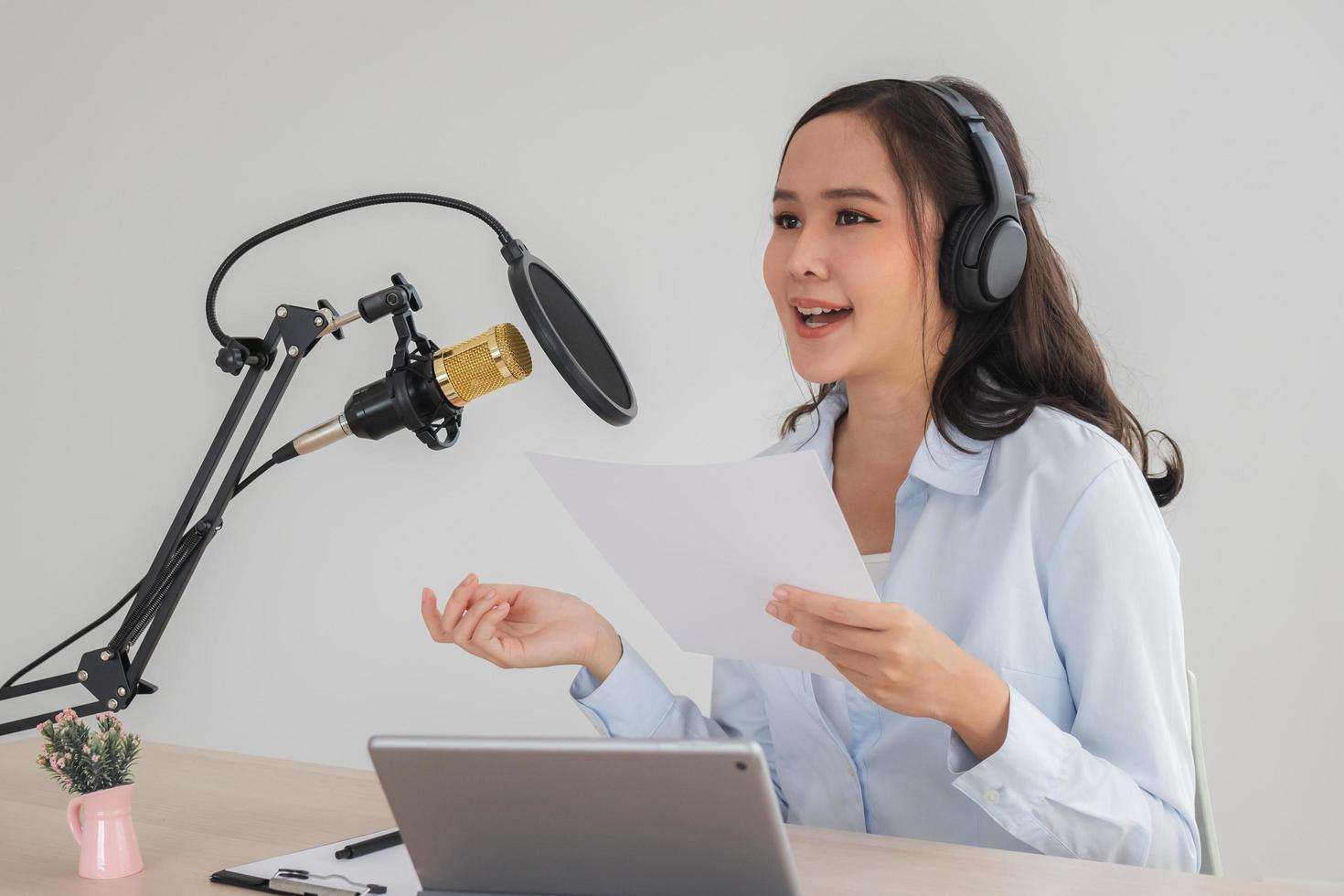 bela jovem asiática apresentadora de rádio trabalhando, definindo o microfone, preparando-se para falar antes de gravar podcast e viver nas mídias sociais. tecnologia de on-air on-line na transmissão em home studio. foto