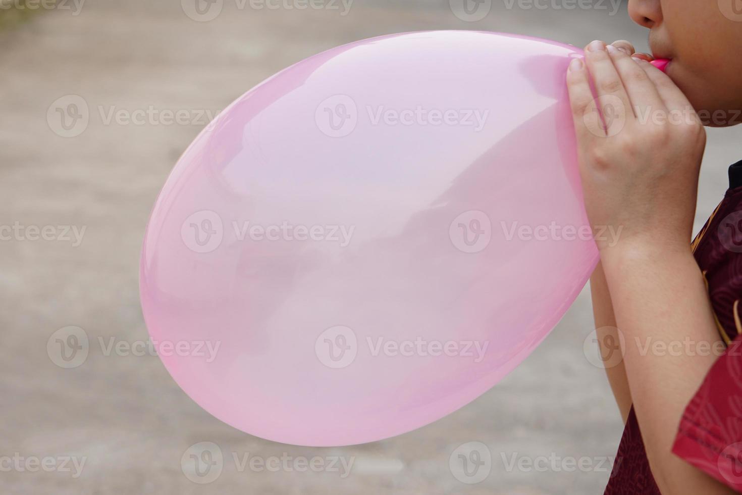 fechar-se Garoto é sopro Rosa balão, infla ar para balão conceito, crianças jogar, brinquedo e equipamento para jogar Diversão jogos ou preparar Festa. foto