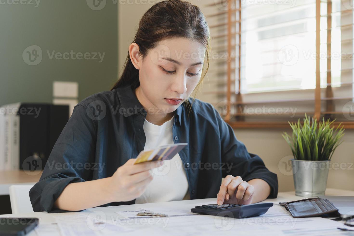 financeiro dever, mão do ásia mulher sentado, segurando muitos crédito cartão, estressado de calcular despesa a partir de fatura ou conta, não dinheiro para pagar, hipoteca ou empréstimo. dívida, falência ou falido foto