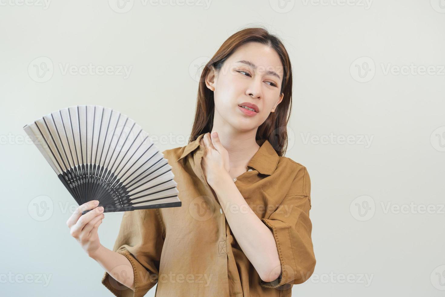 sofrimento verão calor AVC, quente clima, cansado ásia jovem mulher, menina suado e sedento, refrescante com mão dentro sopro, onda ventilador para ventilação quando temperatura Alto às lar, casa.em fundo foto