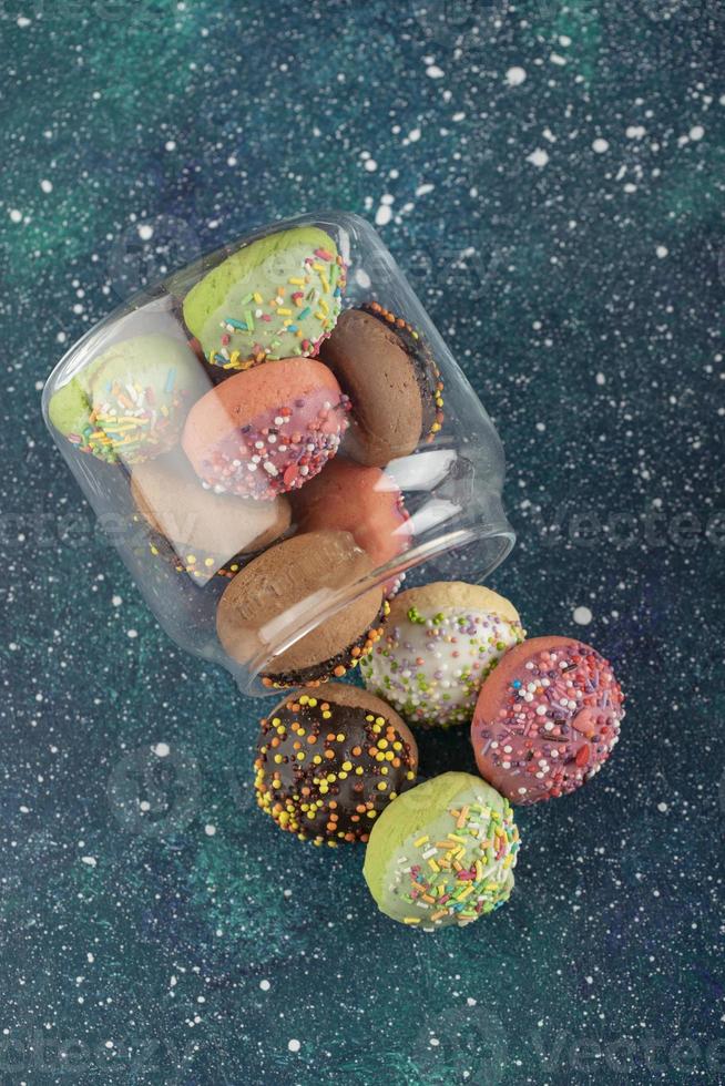 uma jarra de vidro cheia de pequenos donuts coloridos foto