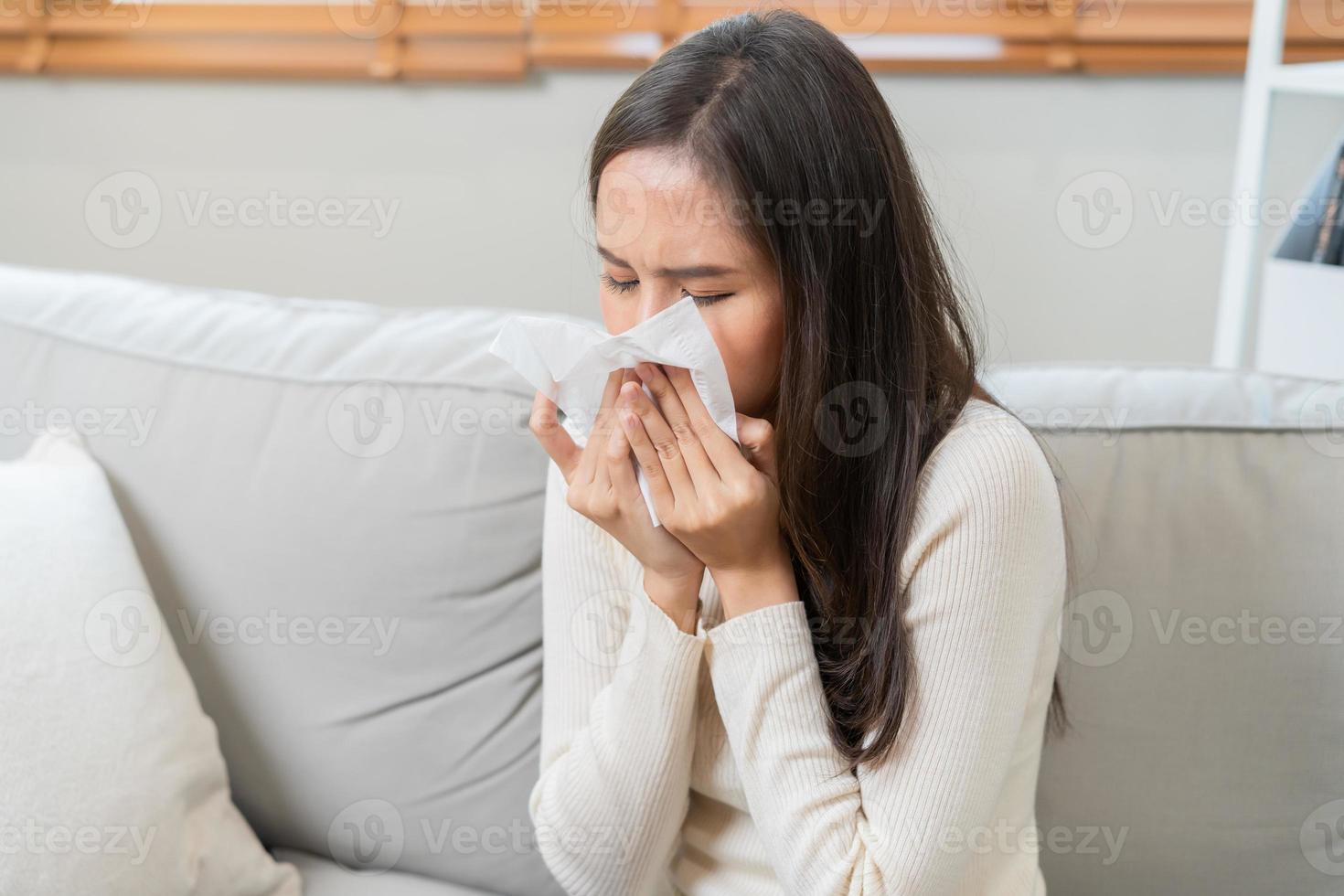 doente, coronavírus covid-19 ásia jovem mulher, menina dor de cabeça debaixo cobertor ter uma febre, gripe e usar lenços papel espirros nariz, escorrendo sentado em sofá cama às lar. saúde Cuidado em vírus pessoa. foto