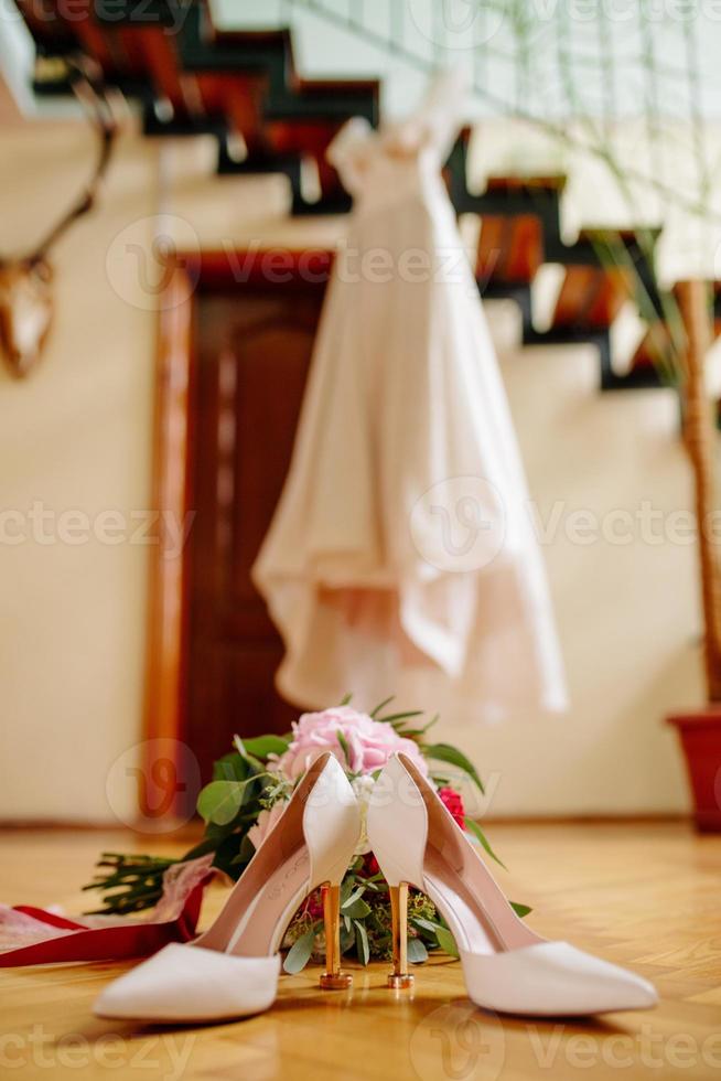 fêmea pés dentro branco Casamento sandálias com uma ramalhete do camomiles foto