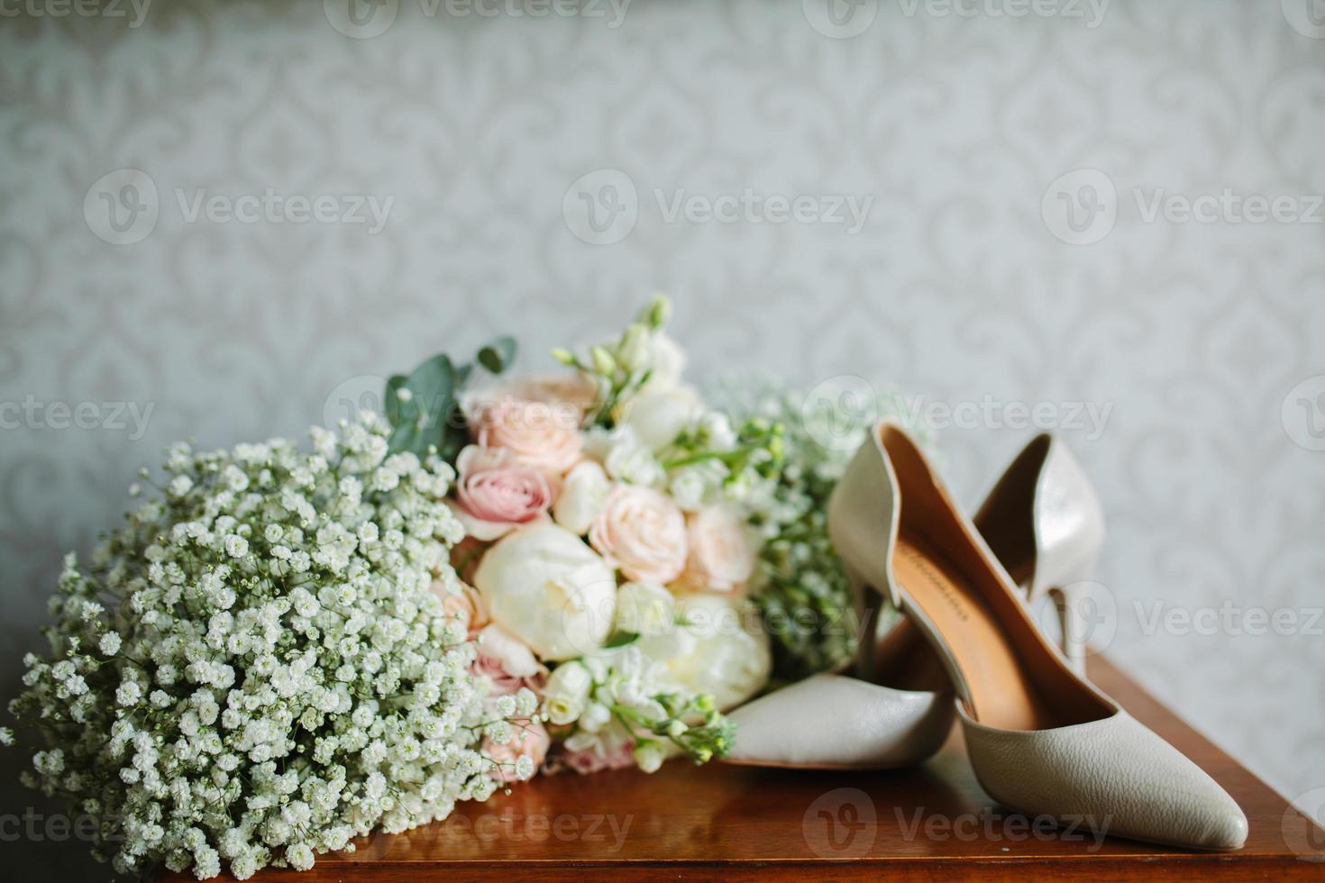 fêmea pés dentro branco Casamento sandálias com uma ramalhete do camomiles foto