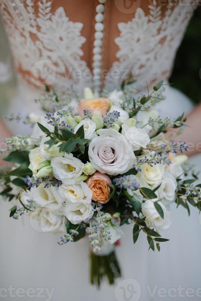 lindo buquê de casamento branco com noiva sentada ao fundo - dof raso foto