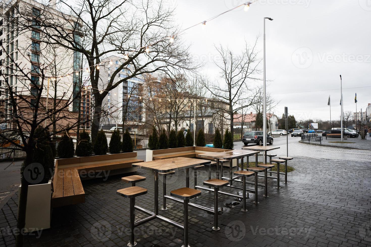 esvaziar cidade cafeteria terraço com mesas e cadeiras, festão do luz lâmpadas. foto