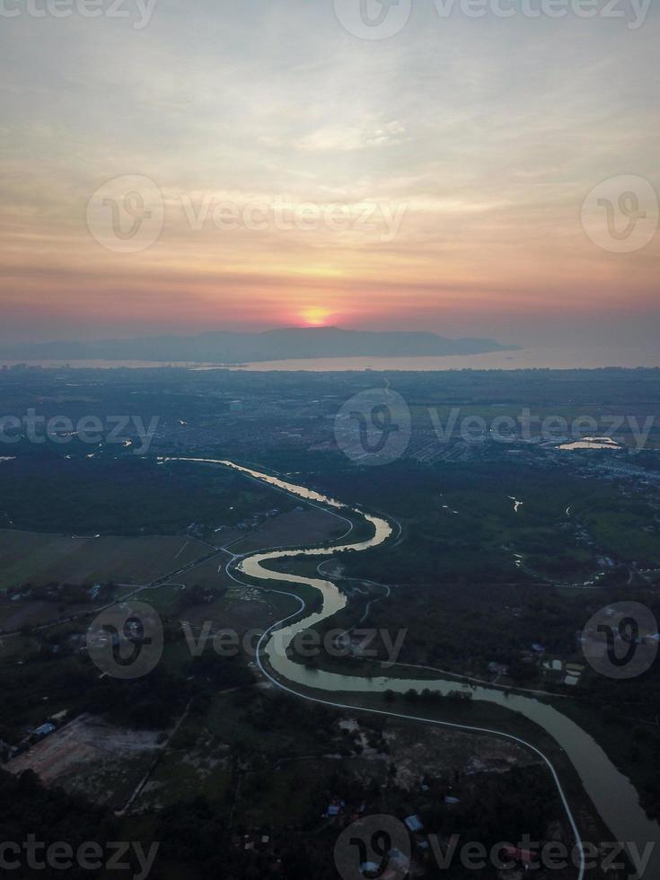 aéreo Visão rio através plantação durante pôr do sol foto