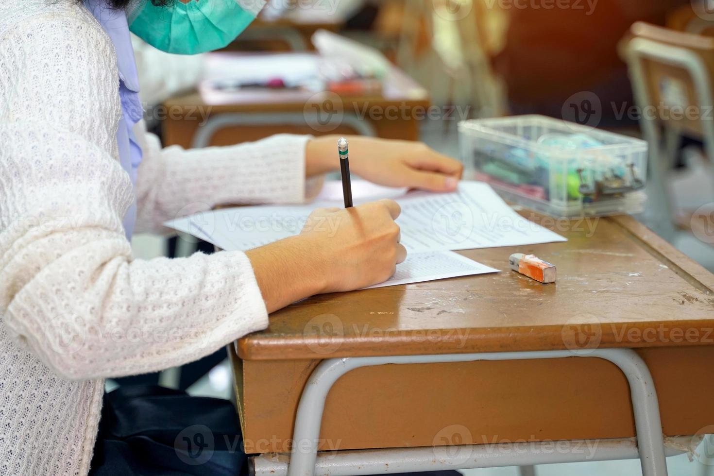 ásia escola crianças levar exames para a medida e avaliar Aprendendo resultados. durante a epidemia situação do a corona vírus de vestindo uma mascarar todos a tempo. suave e seletivo foco. foto