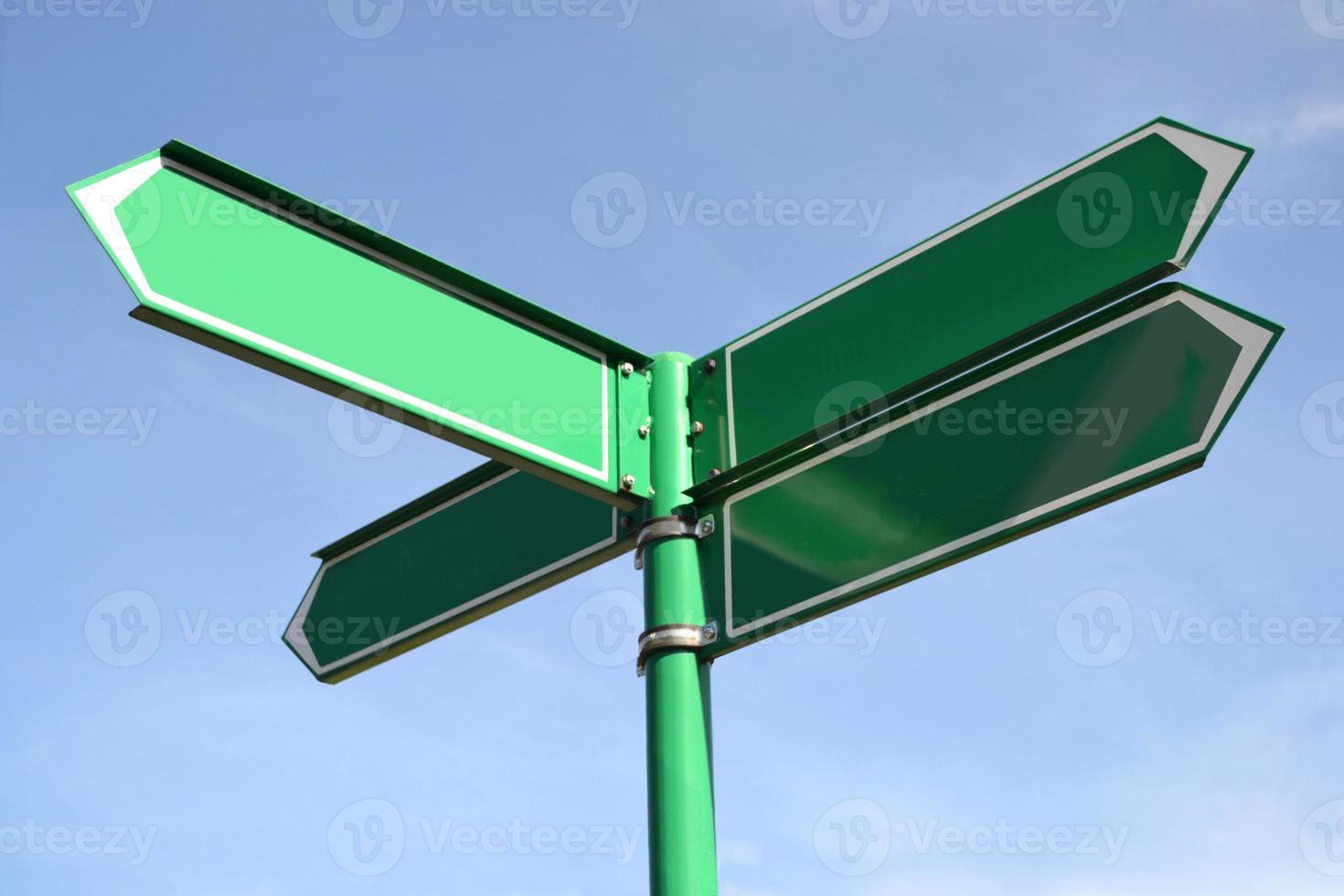 verde metal placa de sinalização com quatro Setas; flechas foto