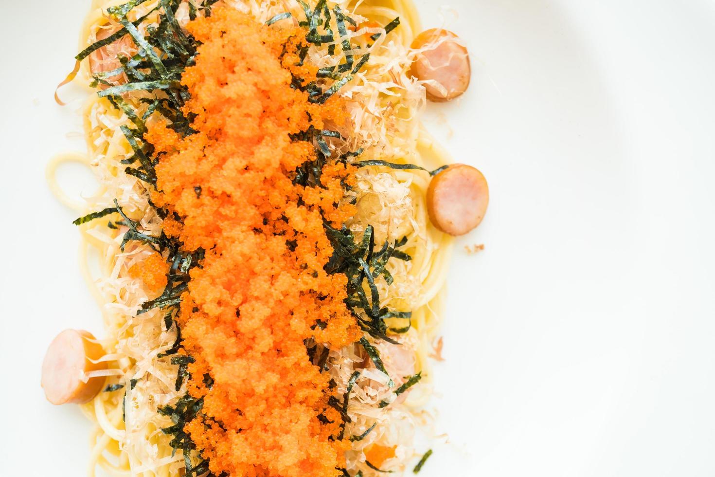 espaguete com linguiça, ovo de camarão, alga, lula seca por cima foto